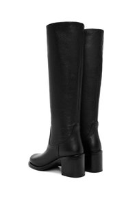Bottes noires en cuir, montantes jusqu'au genou, avec une finition texturée, un bout rond et un talon carré. Présente des coutures lisses sur les côtés.