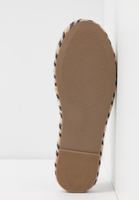 Semelle d’une chaussure espadrille rayée avec une semelle en caoutchouc texturée et une taille 5 marquée au centre.