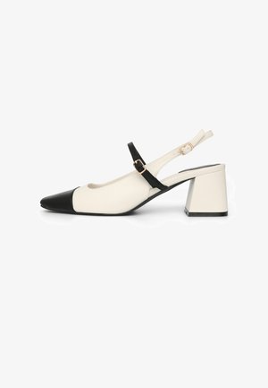 Décolleté slingback in pelle crema e nera, con punta affusolata, tacco largo a blocco e sottile cinturino alla caviglia con fibbia dorata.