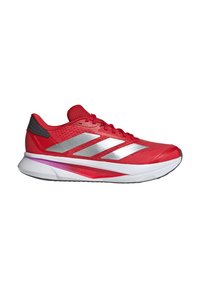 Red athletic shoe with a mesh upper, silver accents, and white sole. Features a cushioned heel and a visible purple midsole detail.
