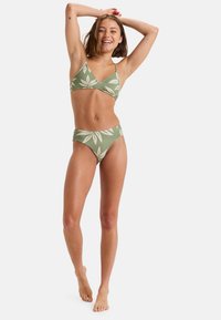 Green bikini with leaf patterns; top features a triangular design, adjustable straps; bottom has a high-waisted cut and matching pattern.