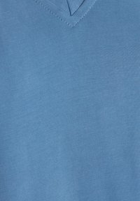Tissu tricoté bleu clair avec une texture lisse, présentant un design à col en V et des détails de couture subtils.