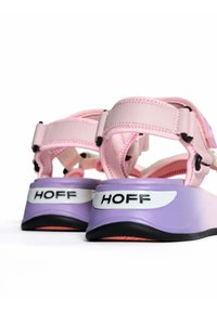 Sandalias en tonos rosa y púrpura con correas ajustables, suelas de goma y detalles en negro. Presenta el logo "HOFF" en el talón. Materiales texturizados.