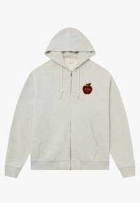 Sudadera gris con cremallera, bolsillo frontal, cordones y un parche decorativo de una manzana en el lado izquierdo. Material de algodón con una textura suave.
