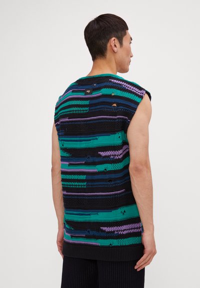 Haut tricot sans manches avec un mélange de rayures bleues, vertes et violettes, comportant des trous visibles et des textures variées. Ourlet noir côtelé.