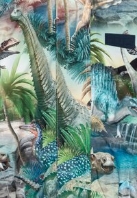 Colorful fabric depicting dinosaurs in a lush jungle setting, featuring prominent textures, foliage, and detailed illustrations of various species.