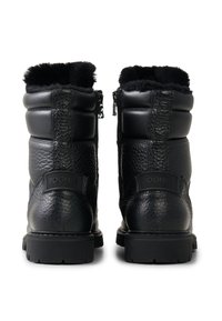 Schwarze Lederstiefel mit strukturierter Oberfläche, Reißverschluss und Pelzbesatz am oberen Rand. Verfügen über eine Markenkennzeichnung auf der Rückseite und eine robuste Gummisohle.