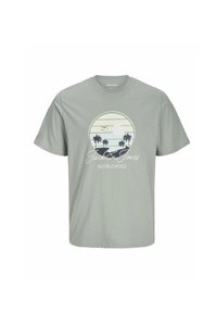 Camiseta de algodón gris con un estampado gráfico de un atardecer, palmeras y pájaros dentro de un diseño circular. El texto dice "Jack & Jones Worldwide."