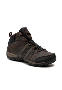 Bota de senderismo Columbia en marrón y negro, con soporte alto para el tobillo, suela resistente y cierre de cordones, diseñada para uso al aire libre.