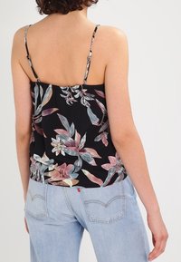 Top floreale con spalline sottili, base nera, stampa floreale multicolore in tonalità di rosa e blu, vestibilità rilassata, tessuto leggero.