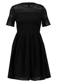 Schwarzes Spitzenkleid mit Kurzärmeln, strukturiertem Material, tailliertem Oberteil, ausgestelltem Rock und aufwendigen Ausschnittmustern. Mit einem Reißverschluss auf der Rückseite.