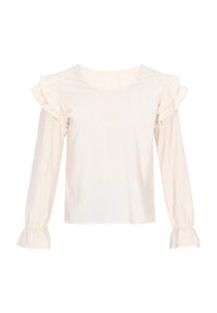 Lys beige bluse med flæser på skuldrene og lange ærmer. Har en ribbet tekstur og samlingselementer ved ærmeafslutningerne.