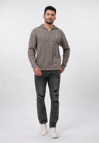 Vaaleanharmaa neulottu pusero, jossa on palmikkokuvio ja vetoketjukaulus. Yhdistetty kuluneisiin tummiin farkkuihin ja valkoisiin tennareihin. Yksinkertainen, rento asu.