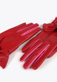 Röda läderhandskar med rosa accenter, med en slät textur och en rosettdetalj på en av handsken. Designen inkluderar distinkta fingerfickor.