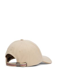Beige baseballcap med bøyelig skjerm, justerbar stropp bak med røde og marineblå striper, samt små ventilasjonshull på siden.
