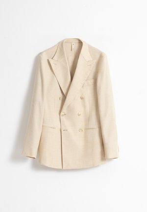 Blazer beige cruzado con solapas de muesca, dos bolsillos con solapa y cuatro botones en cada manga, mostrado sobre un fondo blanco.