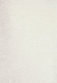 Tejido de punto blanco con una textura suave, que presenta un patrón uniforme y una ligera variación en la tonalidad a lo largo de la superficie.