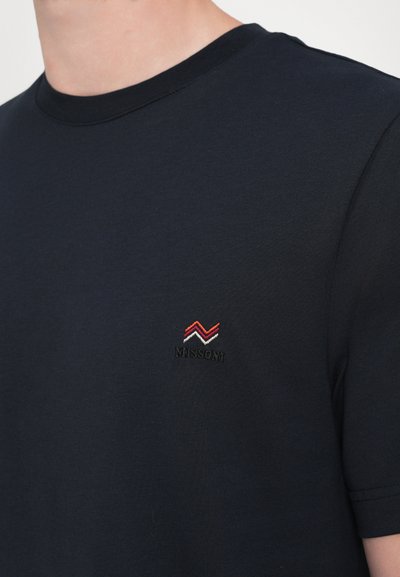 Mornarski majica kratkih rukava od mekog materijala, s malim izvezenim crveno-belim zigzag logotipom na lijevoj strani prsnog koša.