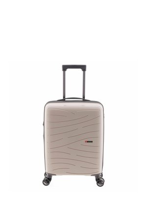 Valise rigide beige avec motifs ondulés, quatre roues pivotantes et une poignée télescopique noire déployée.