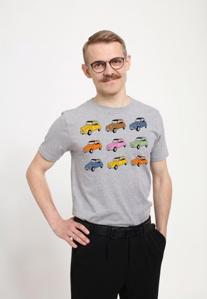 Grå kortærmet t-shirt med et farverigt print af tegneserie-biler i forskellige farver: gul, pink, blå, orange og grøn.