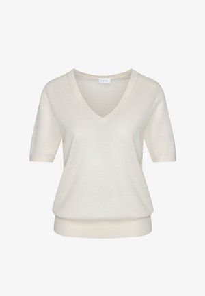 Chemise en maille à manches courtes couleur crème avec col en V et ourlet côtelé, présentée sur un fond blanc.