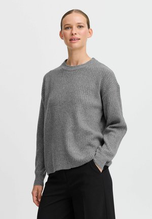 Gray ribbed knit sweater with a round neckline and relaxed fit. Features long sleeves and a slightly curved hem. Paired with black trousers.