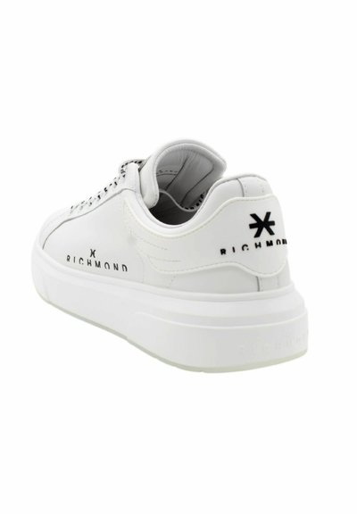 Sneaker in pelle bianca con una finitura liscia e testurizzata, suola bianca spessa e dettagli del logo nero sul tallone e sul lato.