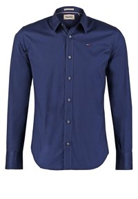 Mörkblå långärmad skjorta i slätt tyg med knäppning fram, klassisk krage och en liten logotyp på vänster bröst.
