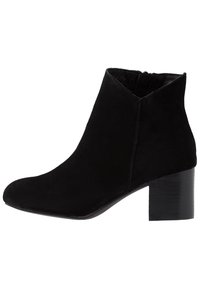 Stivaletto alla caviglia in camoscio nero con punta affusolata e tacco a blocco di altezza media. Lo stivaletto ha una cerniera laterale e una fodera interna liscia.