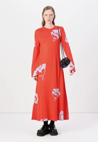 Abito rosso a maniche lunghe con un motivo floreale in azzurro chiaro. L'abito ha una vestibilità morbida, arriva fino alle caviglie ed è realizzato in un tessuto morbido.