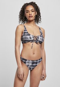 Črno-siv bikini s tie-dye vzorcem, ki vključuje kratko zgornji del z vezavo spredaj in ujemajoče se nizke hlačke. Gladek, raztegljiv material.