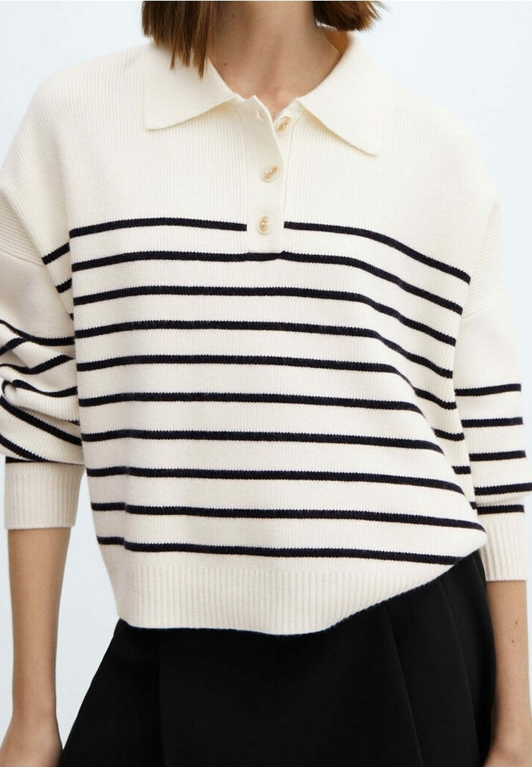 Polo en maille couleur crème, avec des rayures horizontales noires, un col à trois boutons et des poignets et un ourlet côtelés. Manches courtes et décontractées.