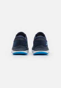 Baskets de course navy avec une tige en mesh respirant, un col rembourré et une semelle extérieure bleu clair dotée de détails de traction texturés.