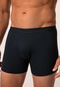 Boxer sportivi neri in cotone con una vestibilità aderente, caratterizzati da una morbida cintura elastica e un design minimalista. Senza motivi né grafiche.