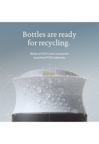 Gros plan sur un bouchon de bouteille blanc avec des gouttes d'eau, le texte indique que les bouteilles sont prêtes à être recyclées, fabriquées à partir de 50 % de matériaux recyclés post-consommation.