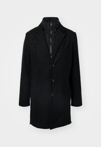 Schwarzer Mantel mit maßgeschneidertem Design, versehen mit einer Knopfleiste, zwei seitlichen Taschen und einer abnehmbaren, mit Reißverschluss versehenen inneren Lage mit hohem Kragen.