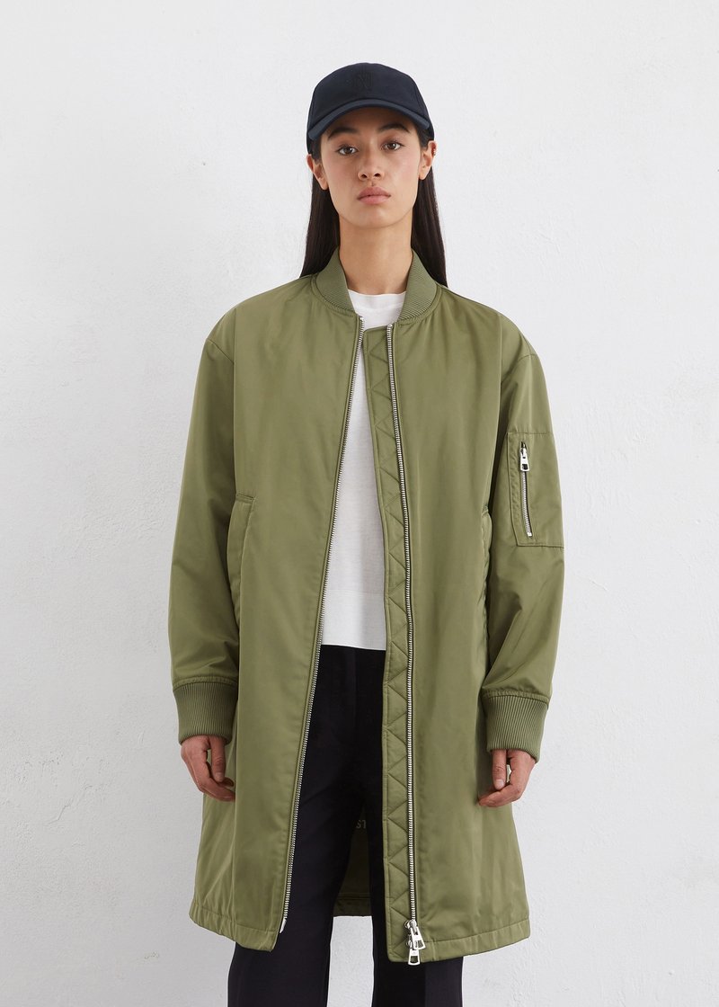 Olivgrüne Bomberjacke mit einem Frontreißverschluss, gerippten Bündchen und Seitentaschen. Verfügt über ein dezentes, gesteppte Futter und eine lässige Passform.