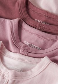 Kolm beebipaita roosade tooni, ümarate kaelustega ja snap-kinniitustega. Pehme puuvillane materjal, korralik õmblus ja brändi silt nähtav.