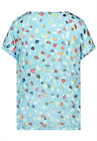 Lockere blaue Bluse mit einem gesprenkelten Muster aus bunten Punkten in verschiedenen Größen. Weicher Stoff mit kurzen Ärmeln und abgerundetem Saum.