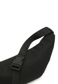 Sac d'épaule en tissu noir avec une texture lisse, doté d'une bandoulière réglable et durable ainsi que d'une fermeture à boucle en plastique.