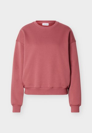 Sweat-shirt rose pâle à col ras du cou avec manches longues, poignets et ourlet côtelés, et nom de la marque discrètement en relief centré sur le devant.