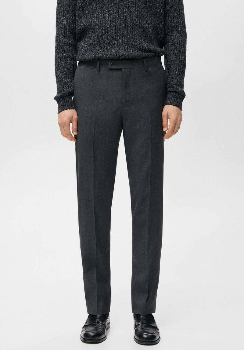 Szare, dopasowane spodnie garniturowe o gładkiej fakturze, wyposażone w szlufki na pasek, przednie kieszenie oraz slim fit. Noszone z ciemnym, dzianinowym swetrem.