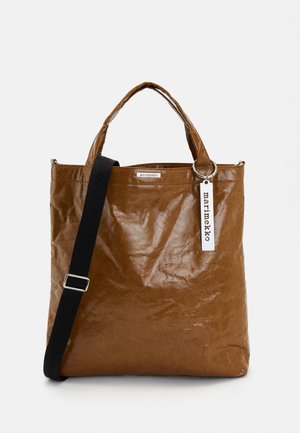 Sac fourre-tout marron en matériau texturé avec un aspect froissé. Dispose de poignées courtes, d'une bandoulière longue et réglable, et d'une étiquette de logo.