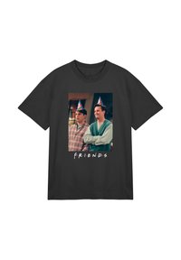 Černé bavlněné tričko s potiskem dvou mužů v párty kloboucích a textem "PŘÁTELÉ" v bílé barvě pod obrázkem.