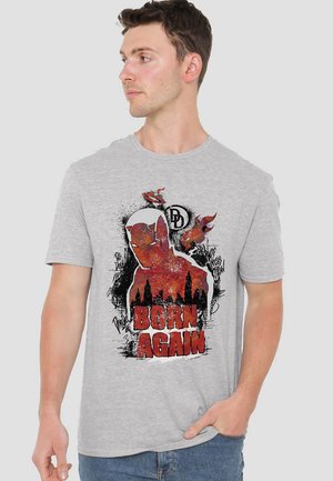 Gray cotton T-shirt featuring a bold graphic of a superhero silhouette, "BORN AGAIN" in red, with a distressed design and city skyline.
