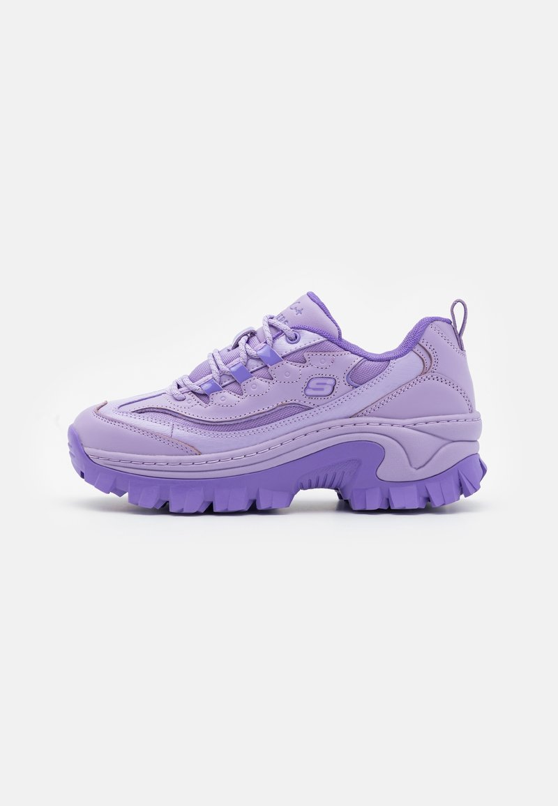 Chaussure de sport violette avec une semelle épaisse, une tige en synthétique texturé et un col rembourré. Équipée de lacets et d'une languette au niveau du talon.