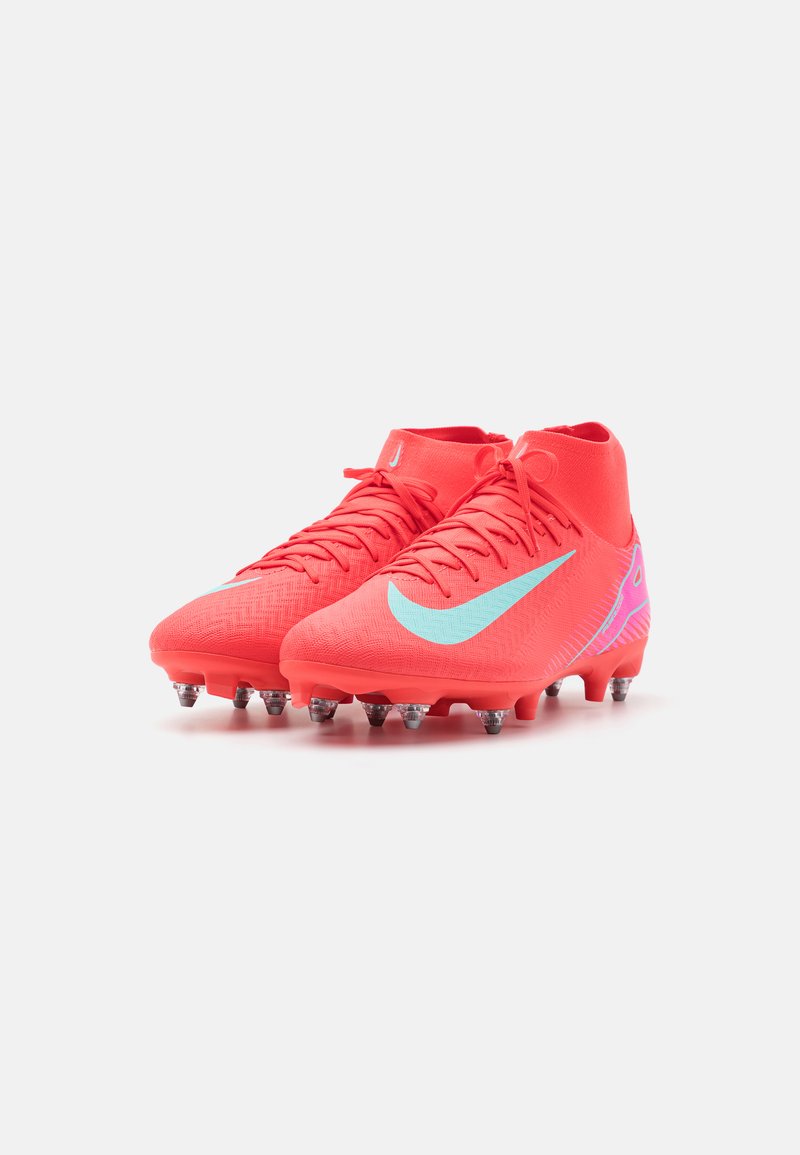 Des crampons de football rouge vif avec une tige texturée, présentant un swoosh bleu clair et des accents violets. Semelle à crampons pour une traction optimale.