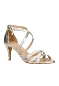 Gouden metallic strappy sandalen met hoge hakken, met een spitse teen, dunne bandjes, een zijgesp en een 7 cm hoge stiletto hak. Gladde textuur.