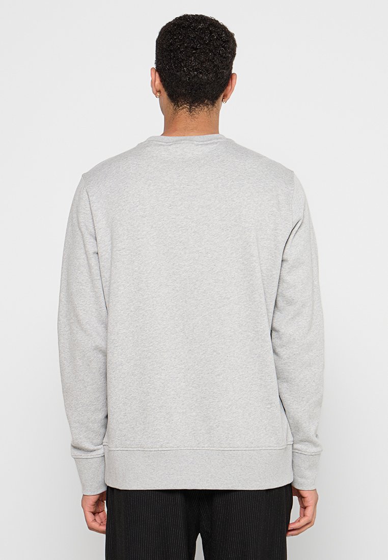 Szara bluza z miękkiego materiału, posiadająca długie rękawy i okrągły dekolt. Tył ma prosty, czysty design bez grafik.