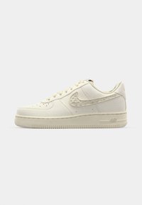 Nike Air Force 1-teniske v off-white platnu, ki imajo teksturiran swoosh, okroglo konico, ravne vezalke in vzorčast gumijast podplat.